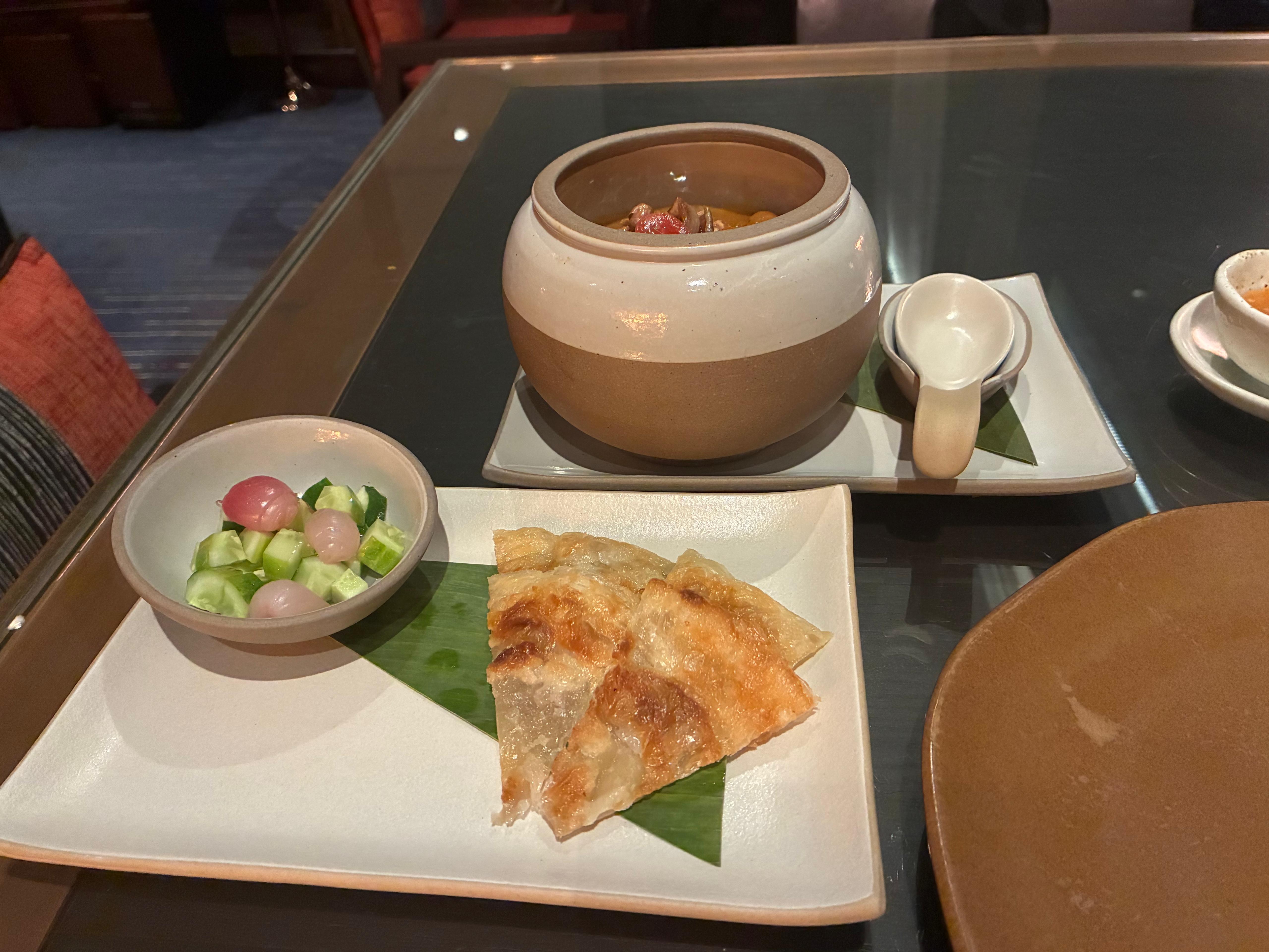 Massaman curry in a ceramic pot with roti and cucumber relish at Saffron, Banyan Tree Bangkok